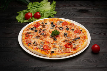 assorted pizza sliced into pieces with cheese, tomato and olives