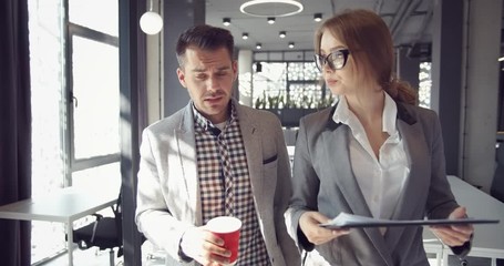 Businessman and lady assistant walking in office, female showing boss prepared report - Powered by Adobe
