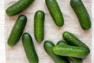 Ripe organic mini baby cucumbers on cloth, overhead view. Flat lay, top view, from above.
