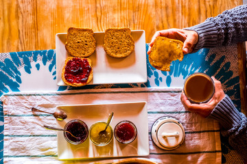 Above view of unrecognizable adult woman having morning breakfast with toasted bread and marmaledes at home or hotel - healthy lifestyle and travel concept people