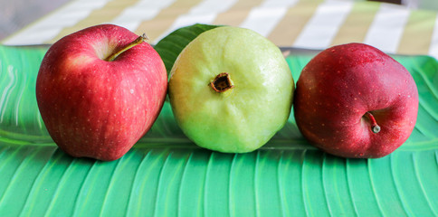 Apples and guava that are arranged on the table