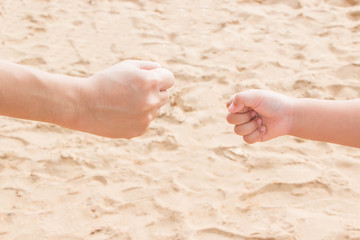 Father's and fists' hands shot rock-paper-scissors at the seaside