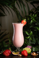 strawberry milkshake in a tall glass decorated with a flower