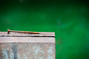 Rust screw lies on a vise, soft focus