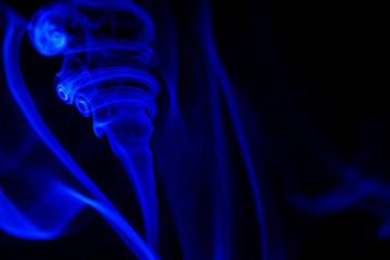blue smoke from aromatic sticks on a black background