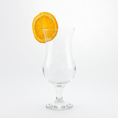 Empty glass with orange slice on white background