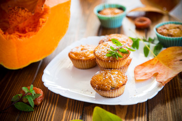 baked sweet pumpkin muffins with dried apricots inside,