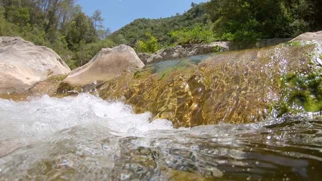 Water flowing in a rocky river seen from water surface and moving camera underwater, Spain, La Muga, Catalonia