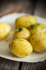 boiled young potato with butter and dill in a plate