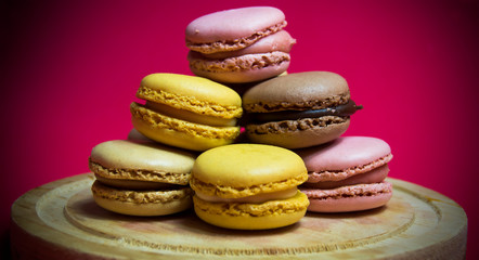 Colored macarons isolated on wooden dish, typical French dish