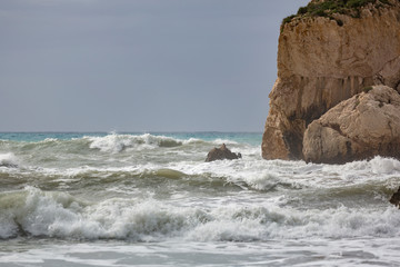 Fototapeta na wymiar Wave splashes against Aphrodite's Rock, Cyprus.