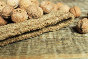  Walnuts lie on a rag bag. Wood background.