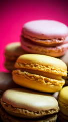 Colored macarons isolated on wooden dish, typical French dish