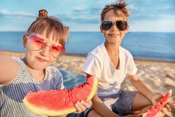Little children with watermelon taking selfie on sea beach