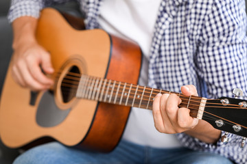 Fototapeta na wymiar Man playing guitar at home, closeup