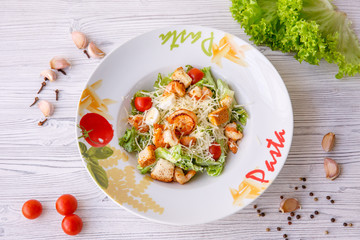 Caesar salad with seafood, the plate says pasta.