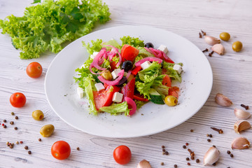 Tasty fresh Greek salad on white wooden table,