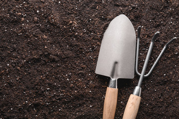 Gardening tools on soil, top view