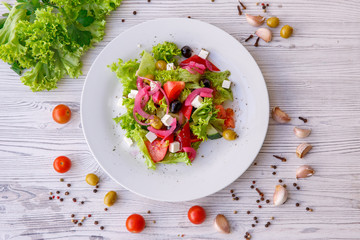 Tasty fresh Greek salad on white wooden table,