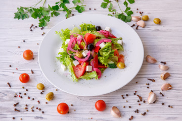 Tasty fresh Greek salad on white wooden table,