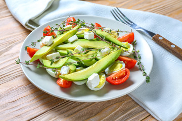 Plate with healthy salad on table