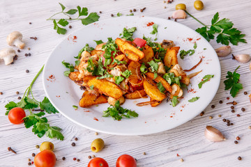 fried potatoes with mushrooms meat onions on a plate wooden white background