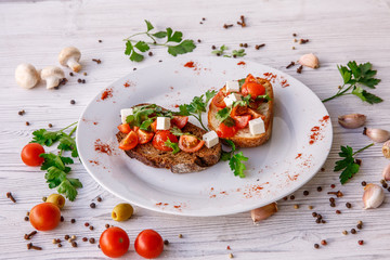 fresh tomato bruschetta. italian food appetizer with cheese  on rustic table 