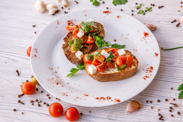 fresh tomato bruschetta. italian food appetizer with cheese  on rustic table 