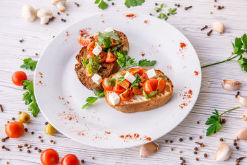 fresh tomato bruschetta. italian food appetizer with cheese  on rustic table 