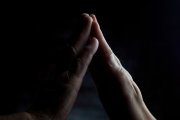 Hands of an old grandmother with young hands of a young girl. Touching palm to palm old mother and child close-up.