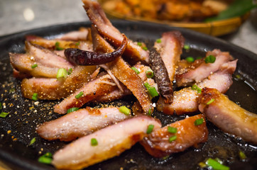 Asian food - slice grilled pork with spicy barbecue sauce serve on iron pan