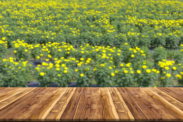 wooden table with blur marigold flower background