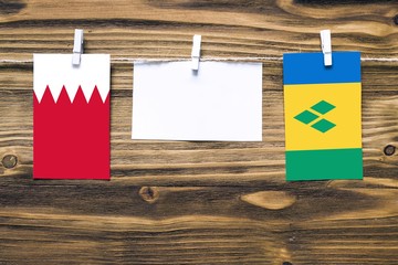 Hanging flags of Bahrain and Saint Vincent And The Grenadines attached to rope with clothes pins...