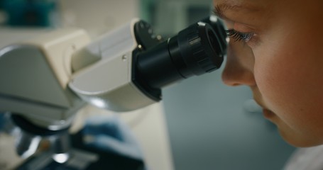Portrait of blond female scientist is analyzing a sample to extract the DNA and molecules with...