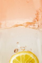 lemon slice in a water glass with soft orange coloring