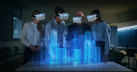 A group of modern designers are using futuristic sophisticated technology vr glasses with augmented...