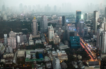 Top view of the streets of Bangkok's business district in the evening in foggy weather. Skyscrapers in the fog. Traffic jam on the street in the business district of Bangkok, Thailand.