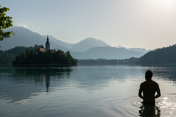 Silhouette of an European man bathing in lake Bled