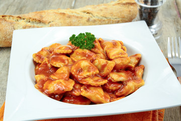 plate of canned ravioli on a wooden table