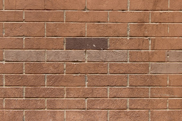 Closeup of a decorative brick wall with one dark brick 