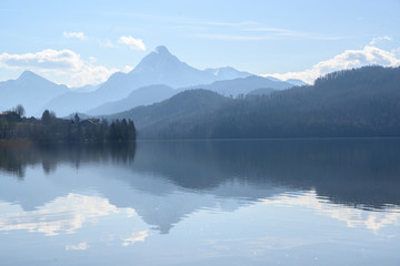 weissensee, idyllic lake in dusty morning light front of the blue mountains of the bavarian alps near füssen in the allgäu, germany, copy space