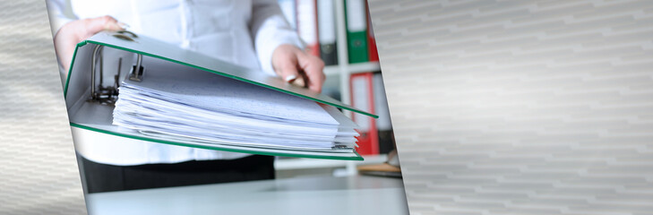 Businesswoman holding a binder; panoramic banner