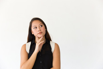 Pensive student girl touching chin and looking at copy space away. Young Latin woman in casual standing isolated over white background. Advertising concept