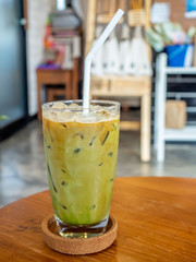 Mixed iced green tea and coffee beverage in glass in coffee shop