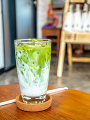 Iced green tea with milk in glass in coffee shop