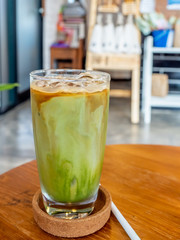 Mixed iced green tea and coffee beverage in glass in coffee shop