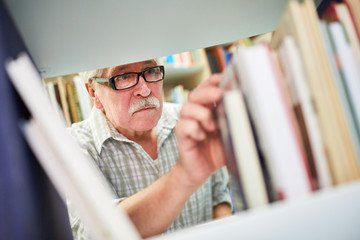 Senior Mann recherchiert in der Bibliothek