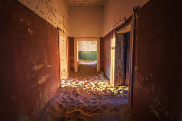 Empty corridor with sand on the ground in the Kolmanskop ghost town, Namibia