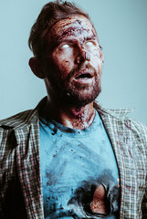 a bloody zombie face with possessed white eyes. Zombie makeup for Halloween, © vulkanov