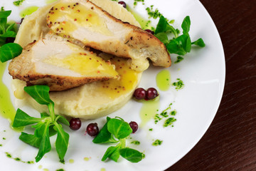 mashed potatoes with chicken breast and herbs in a sauce with berries
